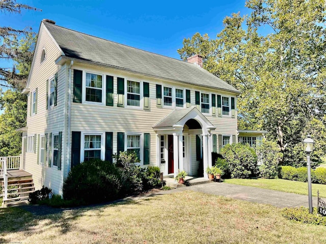 colonial-style house featuring a front lawn