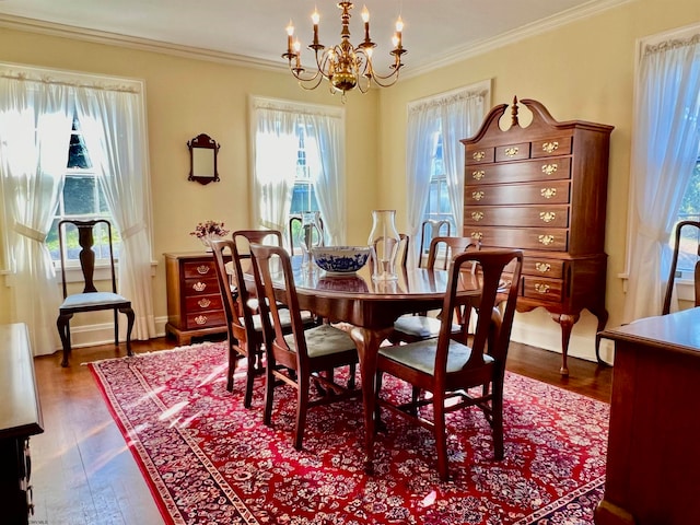 dining space featuring dark wood-type flooring, a healthy amount of sunlight, and a chandelier