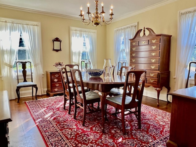 dining space featuring baseboards, a chandelier, dark wood finished floors, and ornamental molding