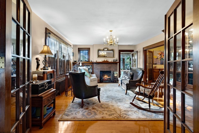 living room featuring plenty of natural light, radiator, hardwood / wood-style flooring, and a fireplace