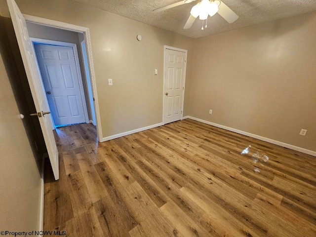 empty room with hardwood / wood-style floors, a textured ceiling, and ceiling fan