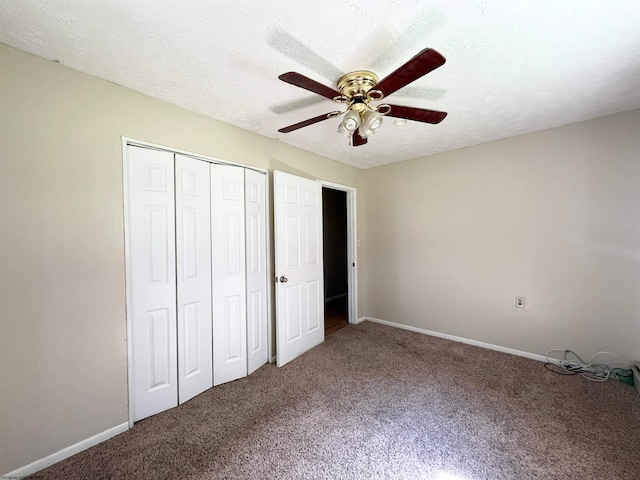 unfurnished bedroom with a textured ceiling, carpet flooring, ceiling fan, and a closet