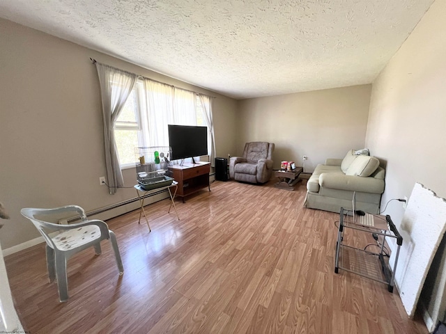 living room featuring a textured ceiling, baseboard heating, and wood-type flooring