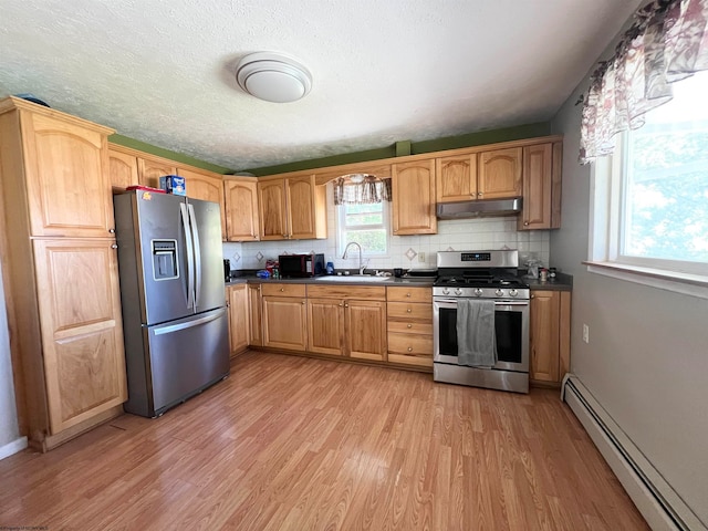 kitchen featuring baseboard heating, stainless steel appliances, sink, and light hardwood / wood-style flooring