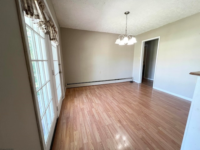 unfurnished room featuring light wood-type flooring, a baseboard radiator, an inviting chandelier, and a textured ceiling