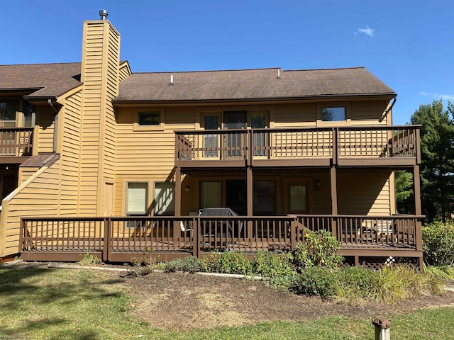 rear view of house with a balcony and a wooden deck