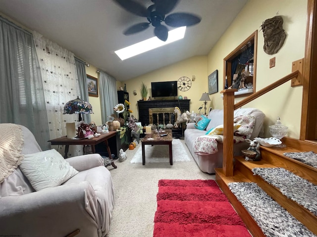 living room with vaulted ceiling, ceiling fan, a fireplace, and carpet flooring