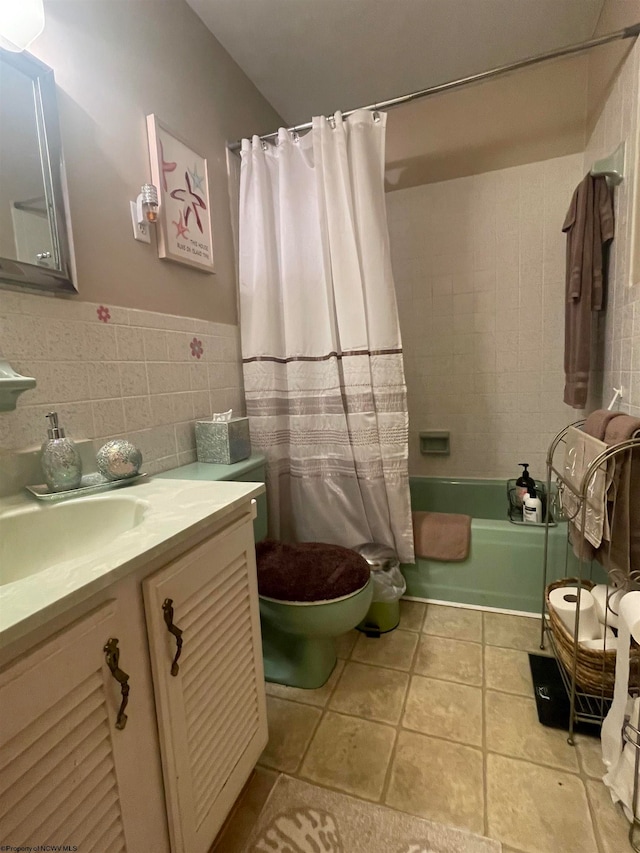 full bathroom with tile walls, shower / tub combo with curtain, vanity, and toilet