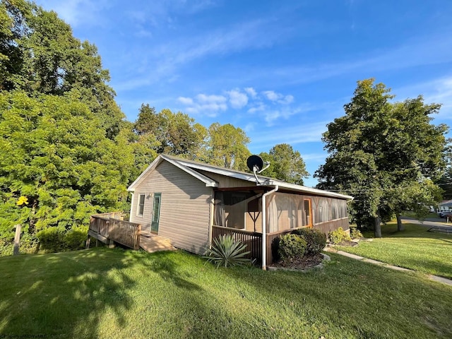 view of side of home featuring a lawn and a sunroom