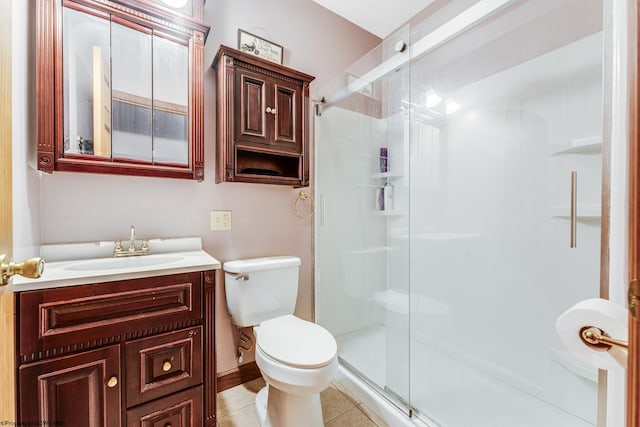 bathroom featuring tile patterned floors, vanity, toilet, and a shower with shower door