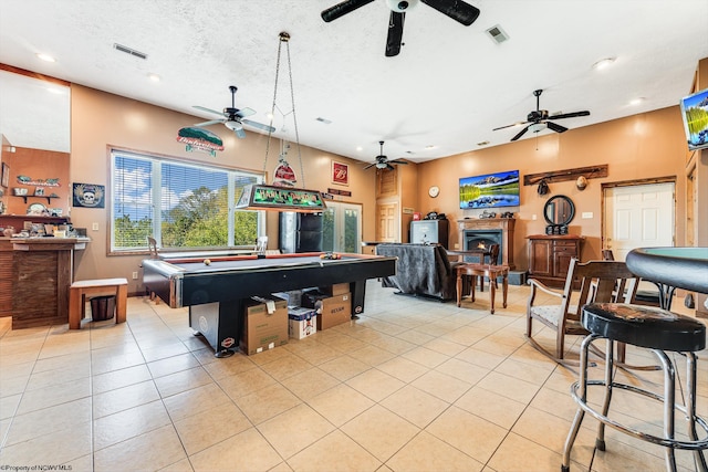 rec room with pool table, ceiling fan, light tile patterned floors, and a textured ceiling