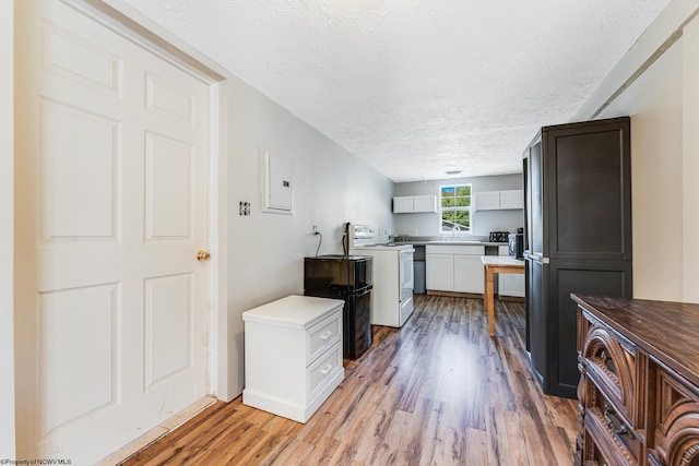 kitchen with a textured ceiling, light hardwood / wood-style floors, white electric range oven, electric panel, and white cabinets