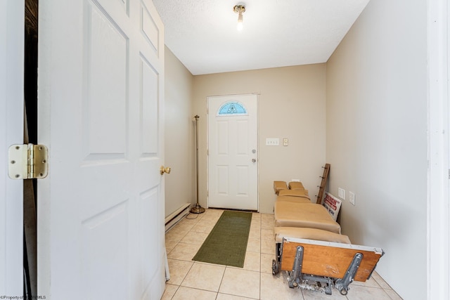 entrance foyer with a textured ceiling, baseboard heating, and light tile patterned flooring