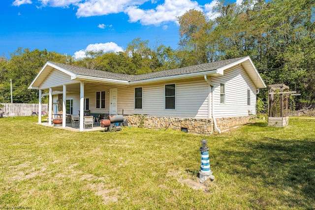 rear view of property featuring a lawn and a patio