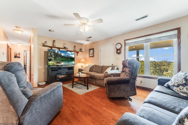 living room with wood-type flooring and ceiling fan