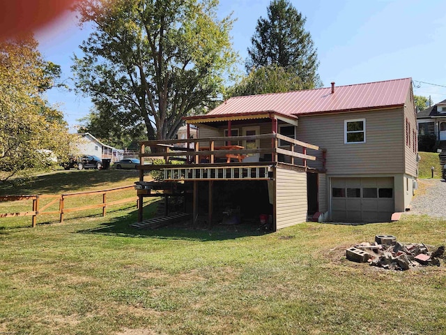 back of property with a garage, a wooden deck, and a yard