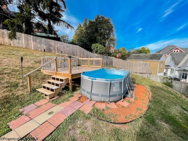 view of pool with a wooden deck and a yard