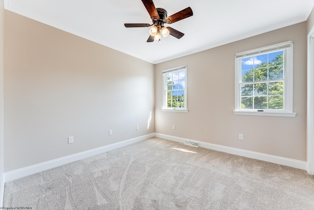 unfurnished room with ornamental molding, ceiling fan, and light colored carpet