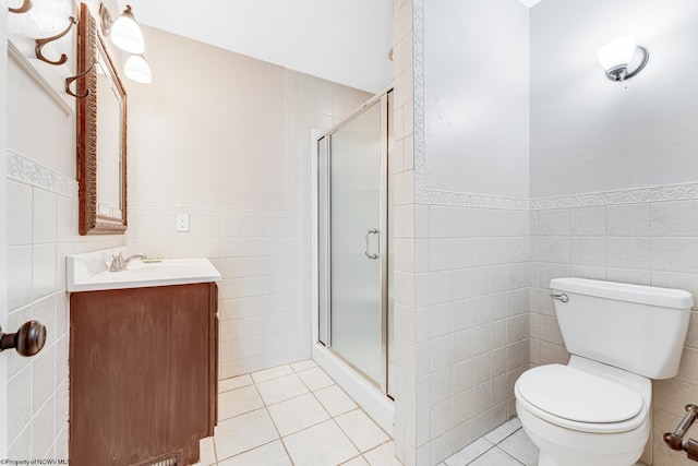 bathroom with tile walls, a stall shower, vanity, and tile patterned flooring