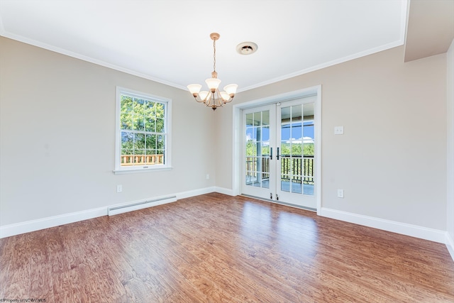 spare room with hardwood / wood-style floors, crown molding, baseboard heating, and a chandelier