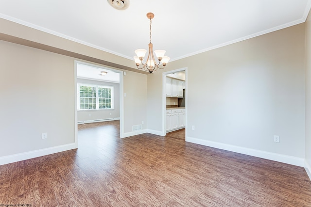 spare room featuring wood-type flooring, ornamental molding, and a chandelier