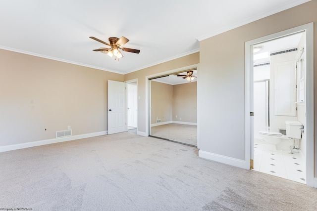 carpeted empty room with visible vents, baseboards, crown molding, and ceiling fan