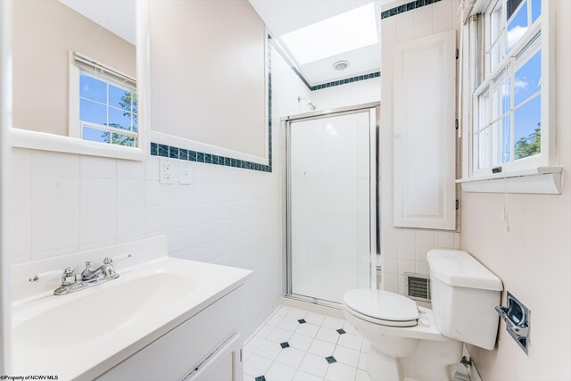 full bath featuring visible vents, toilet, vanity, a stall shower, and tile walls