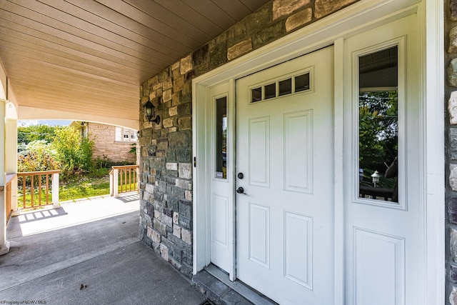 entrance to property with stone siding and covered porch