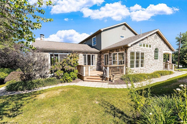 rear view of property with a wooden deck and a yard