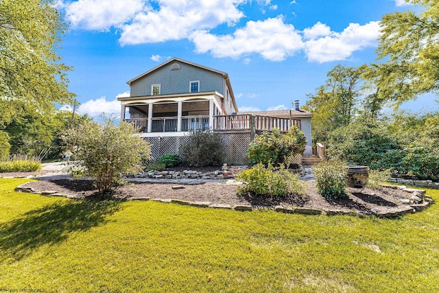 rear view of house featuring a lawn, a sunroom, and a wooden deck