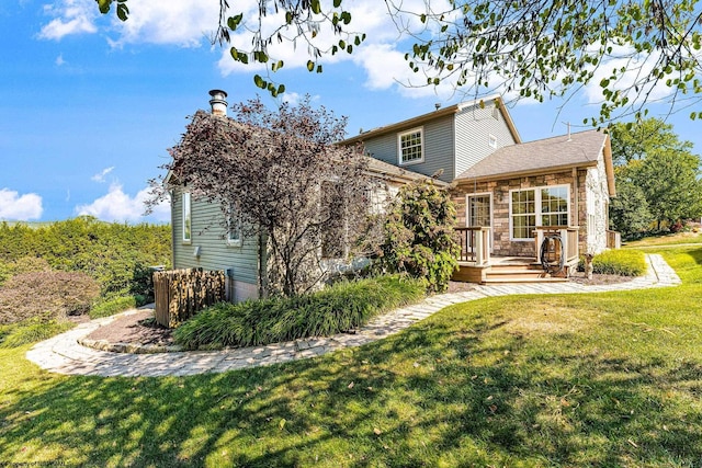 view of front of home with a wooden deck and a front yard