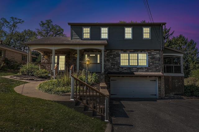view of front facade with aphalt driveway, stone siding, covered porch, an attached garage, and stairs