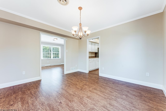 unfurnished room featuring an inviting chandelier, crown molding, wood finished floors, and baseboards