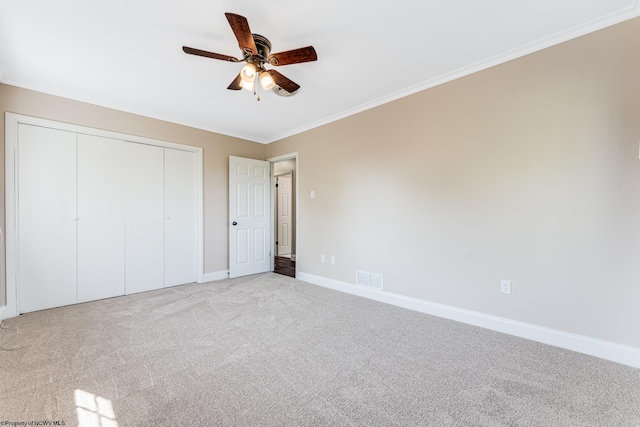 unfurnished bedroom featuring ceiling fan, light colored carpet, and ornamental molding