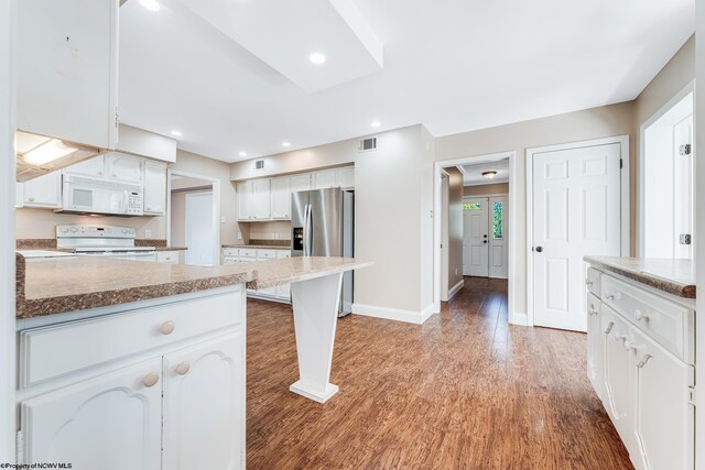 kitchen with light wood-type flooring, visible vents, white appliances, white cabinets, and baseboards