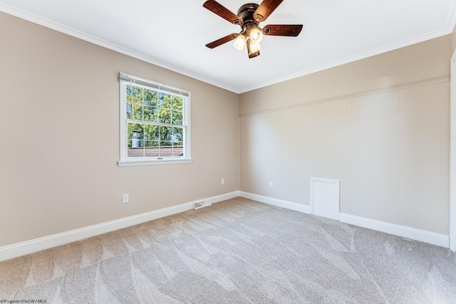 empty room with ceiling fan, crown molding, and carpet flooring