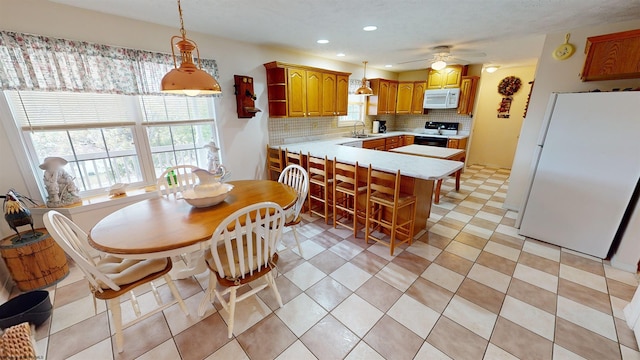 dining room with light tile patterned floors, sink, and ceiling fan