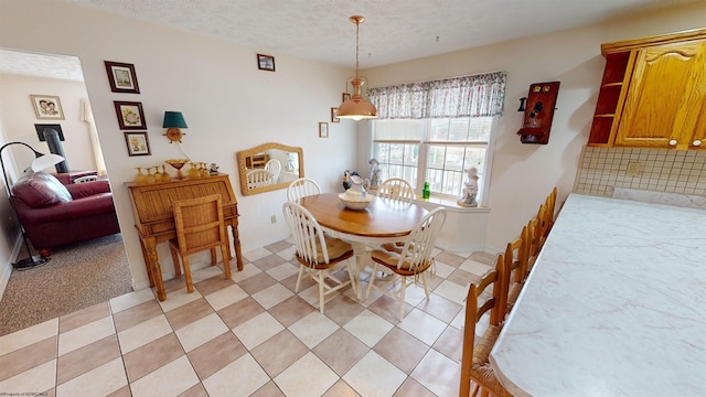 carpeted dining room with a textured ceiling