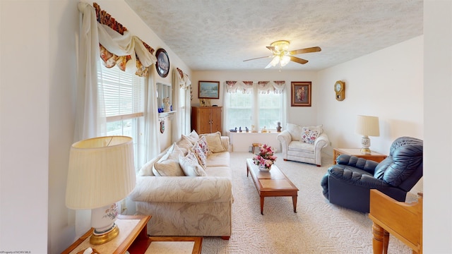 carpeted living room with a textured ceiling and ceiling fan