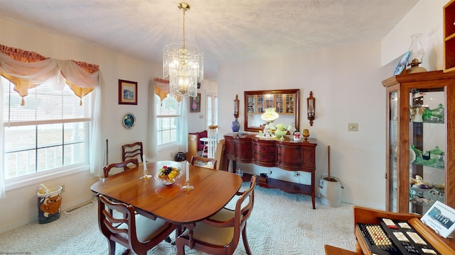 carpeted dining area with an inviting chandelier and a textured ceiling