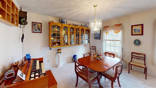 dining room featuring light colored carpet, an inviting chandelier, and a textured ceiling