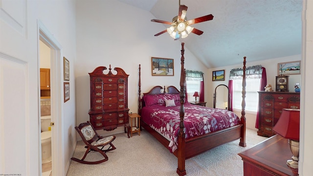 carpeted bedroom featuring ceiling fan, ensuite bathroom, and high vaulted ceiling