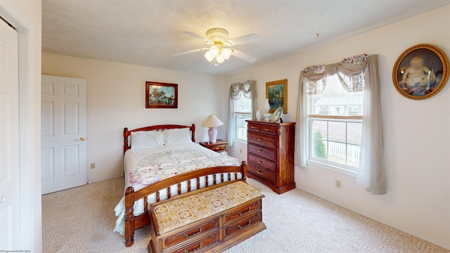 carpeted bedroom featuring a textured ceiling and ceiling fan