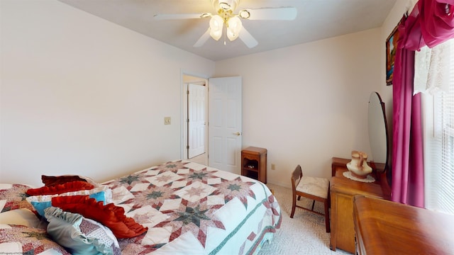 bedroom with multiple windows, ceiling fan, and light colored carpet