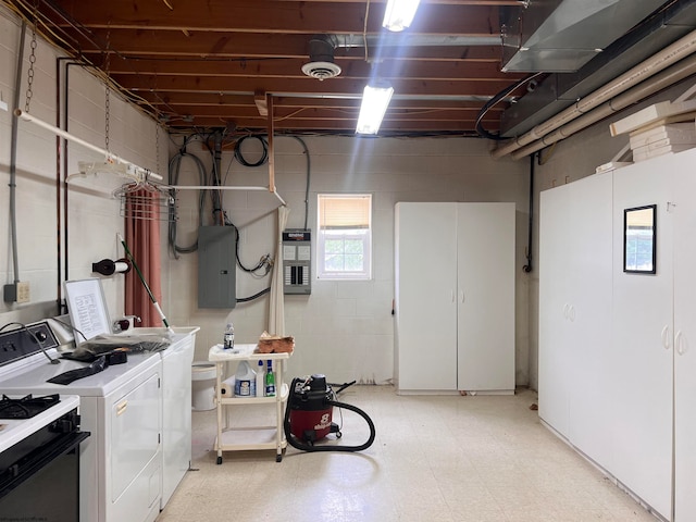 basement featuring electric panel and washing machine and clothes dryer