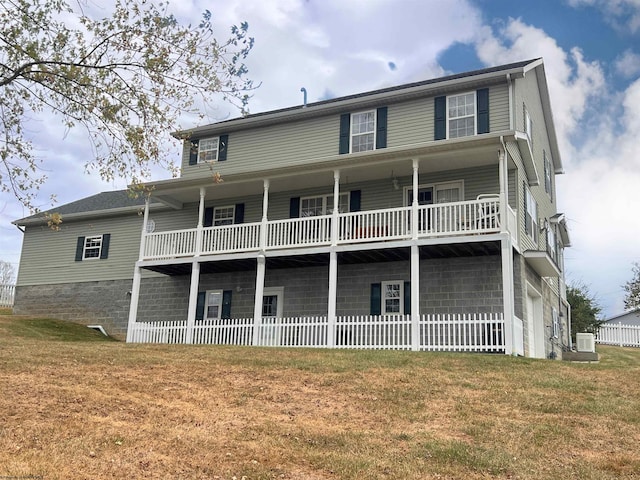 rear view of house featuring a balcony and a lawn