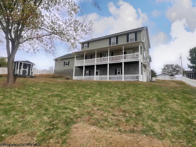 back of property featuring a lawn, a balcony, and a storage unit