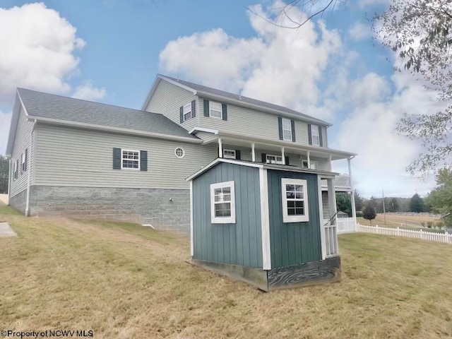 rear view of property with a shed and a yard