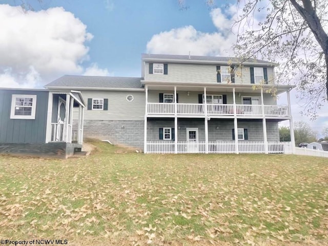 rear view of property with a lawn and a balcony