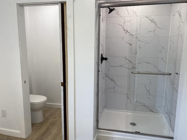 bathroom featuring toilet, walk in shower, and wood-type flooring